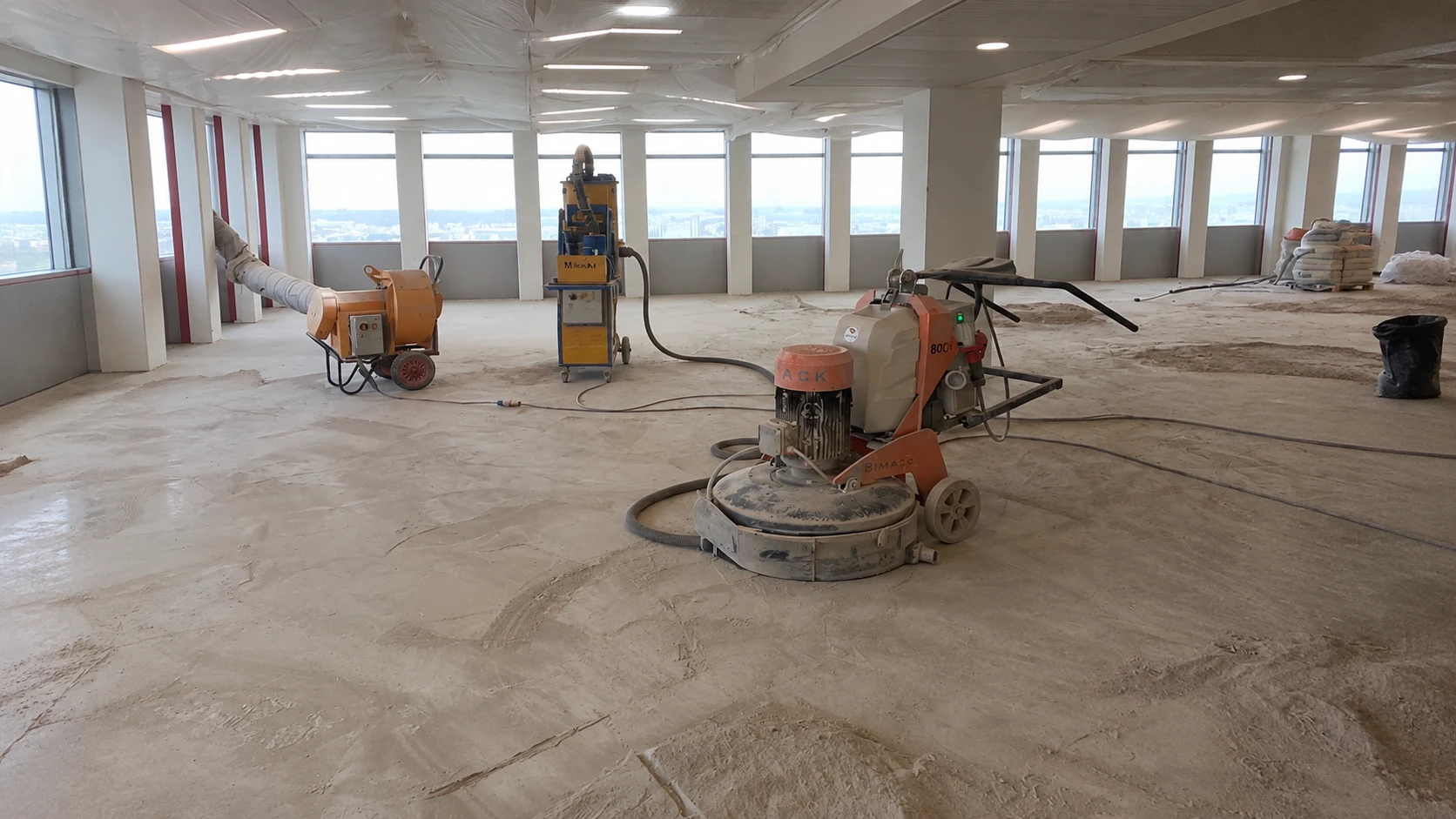 Préparation du support : ponçage du béton à la ponceuse diamant avec aspiration des poussières